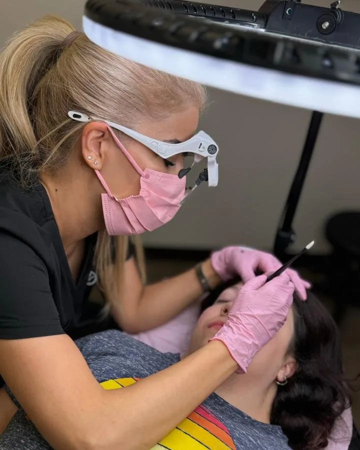 Roya working on a client’s brows under a ring light at the Dr Browz studio.