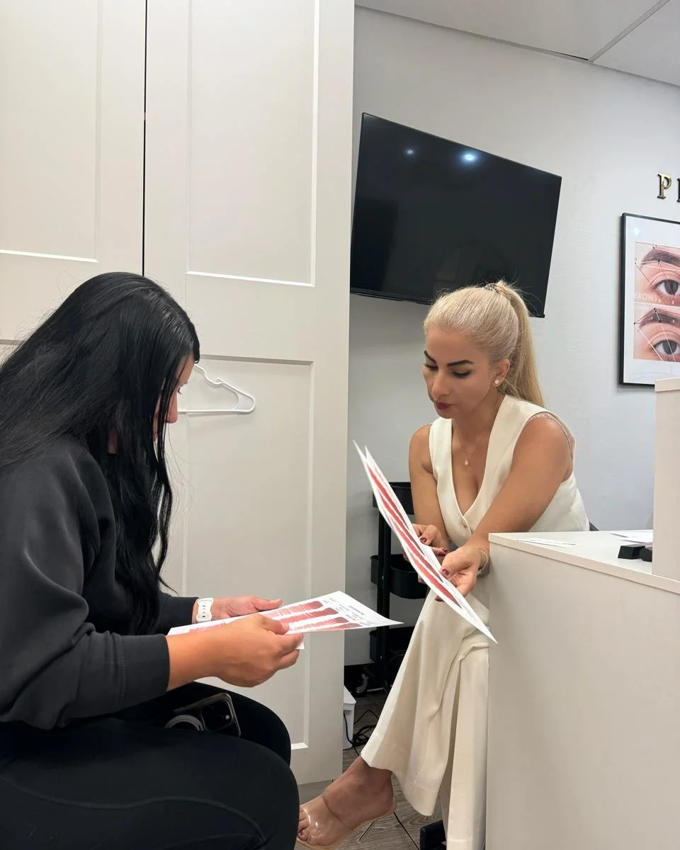 Roya reviewing color options with a client during a consultation at Dr Browz.