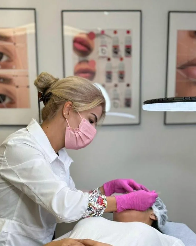 Roya working close to a client’s eye and brow area during a treatment.